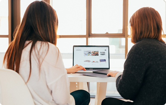 Two women looking at a computer together