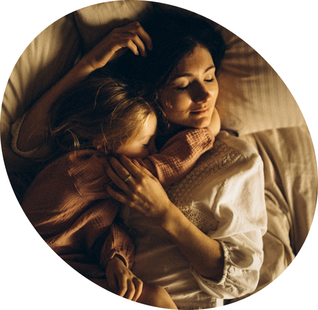 mother laying in bed with little daughter
